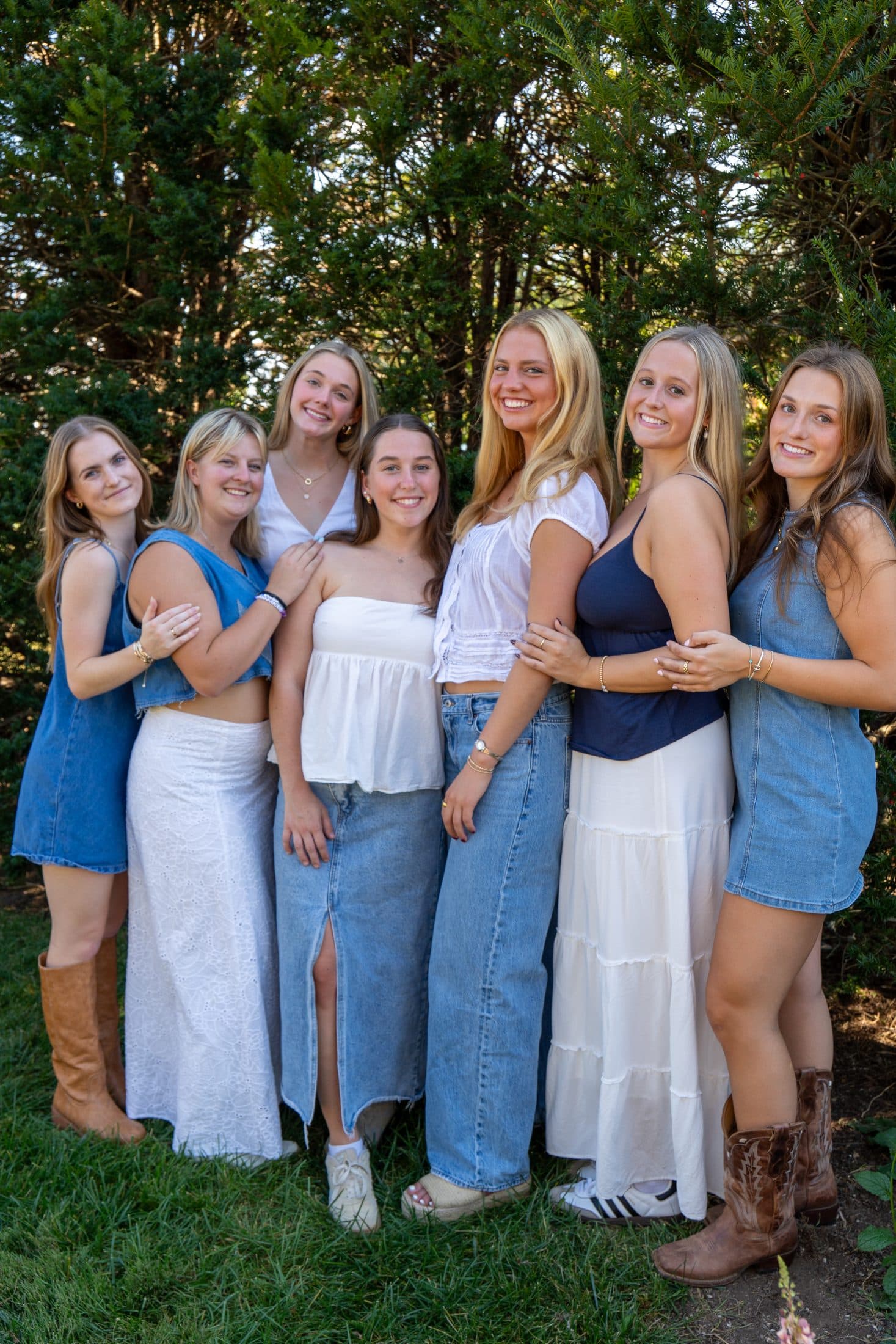 Seven sisters in blue and white gathered beneath the trees