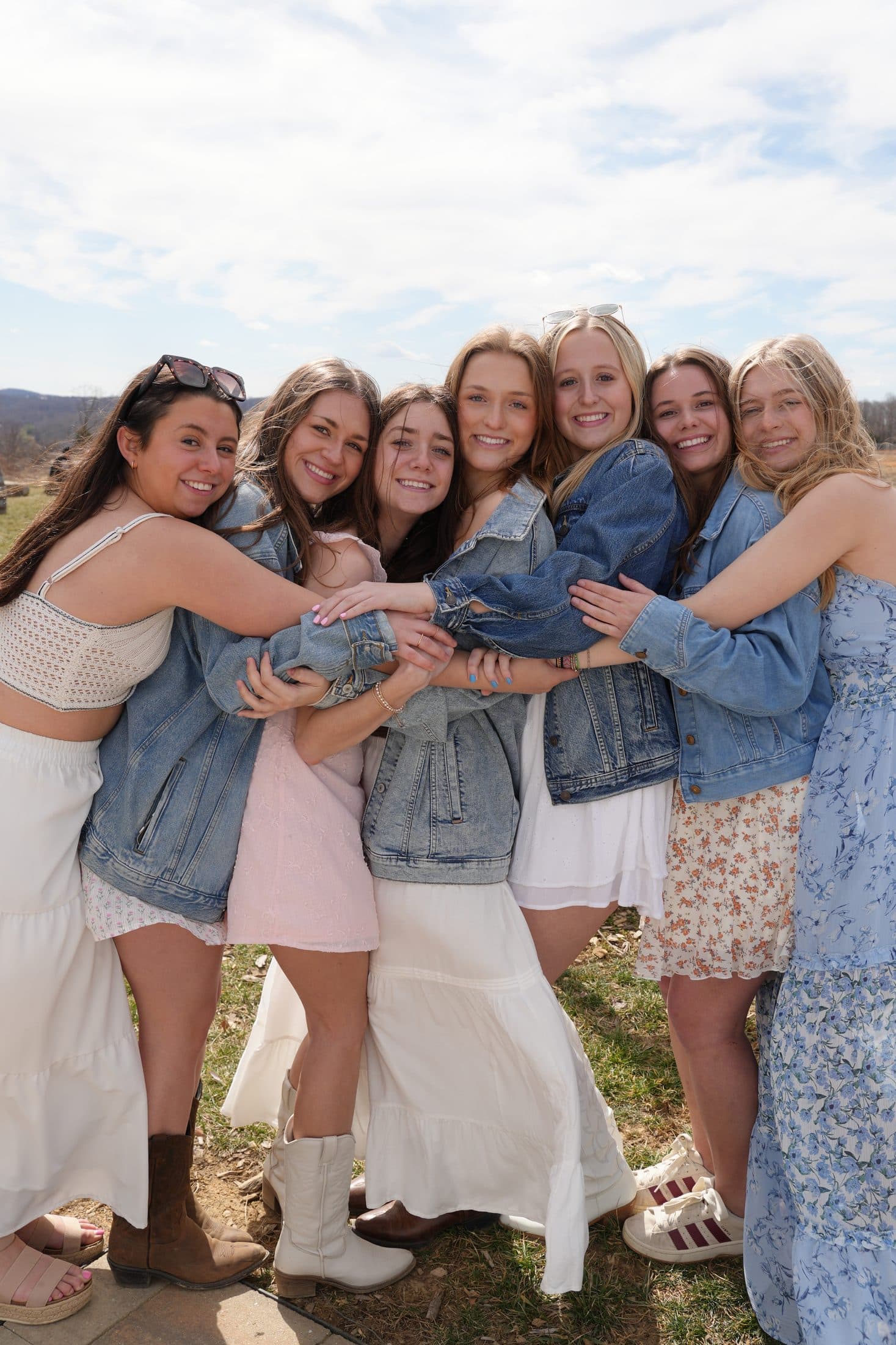 A cluster of friends in matching denim jackets sharing a group hug