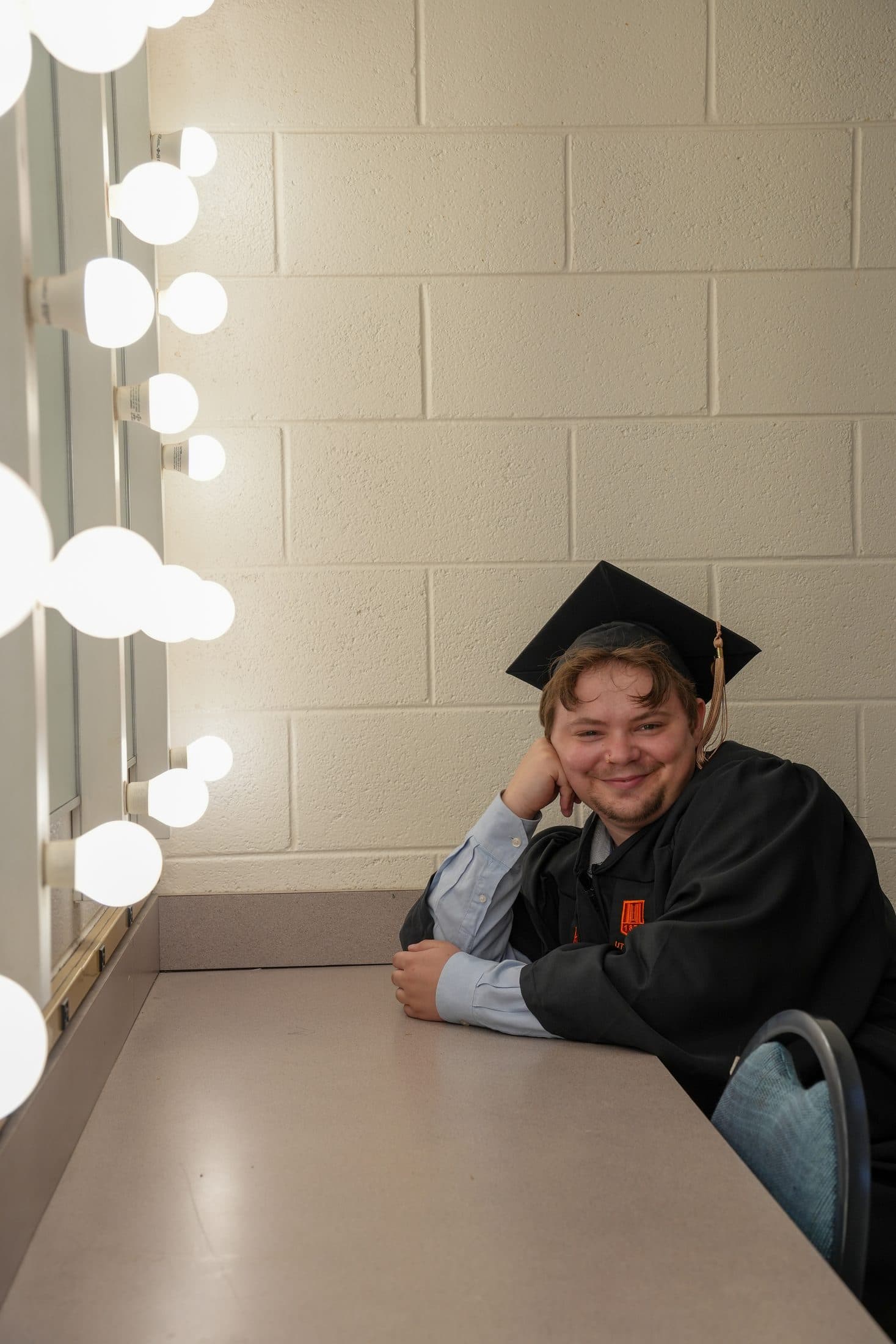 A graduate tossing her cap skyward on the covered campus bridge